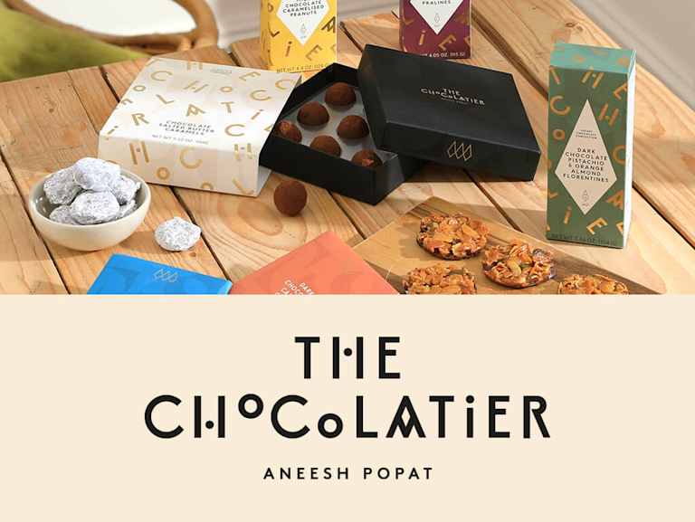 A selection of delicious-looking chocolate truffles and florentines, next to The Chocolatier's logo