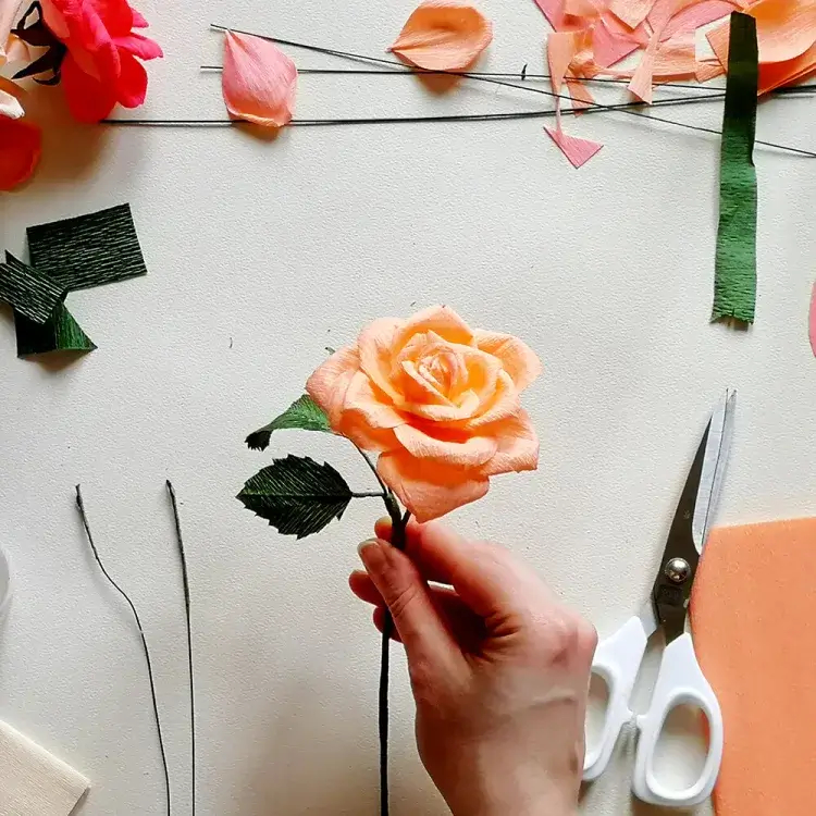 Someone holding a surprisingly realistic paper rose.