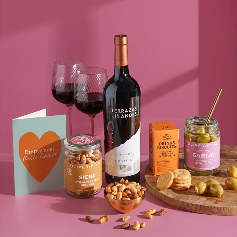 Cosy evening gift box featuring a rich bottle of Terrazas Malbec red wine, savoury chilli nuts, garlic stuffed olives, biscuits, and an "Empty nest. Full heart." card.