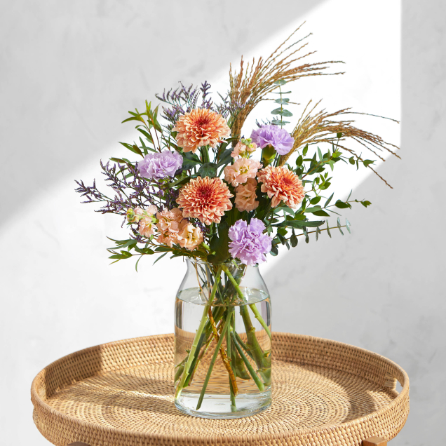 The Owen standout bouquet by Bloom & Wild arranged in a glass vase, featuring tall and unique looking stems
