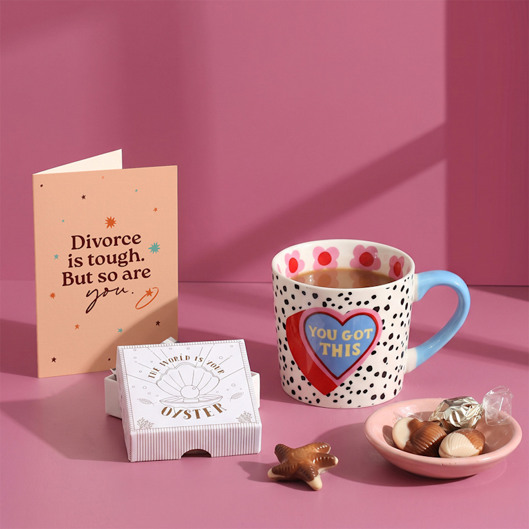 Uplifting gift set with a dotted "You got this" mug, sweet shell-shaped chocolates in a oyster box, and a warm card reading "Divorce is tough. But so are you."