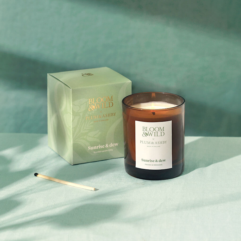The Sunrise & Dew candle on a green background