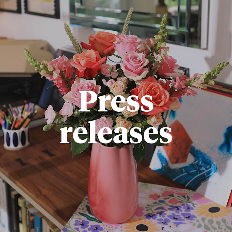 A peachy display of roses, snapdragons and delicate foliage. The words 'Press releases' appear in front of it.