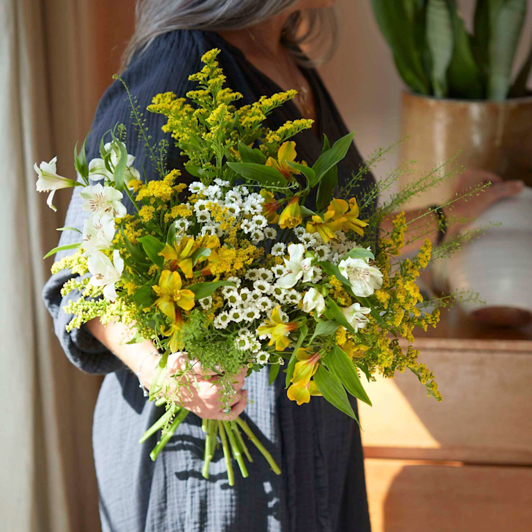 bouquet of yellow and white flowers with green foliage