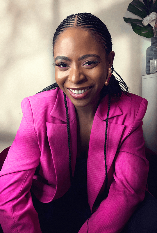 Tiwa smiles and looks directly forward, like she's sharing a secret.
