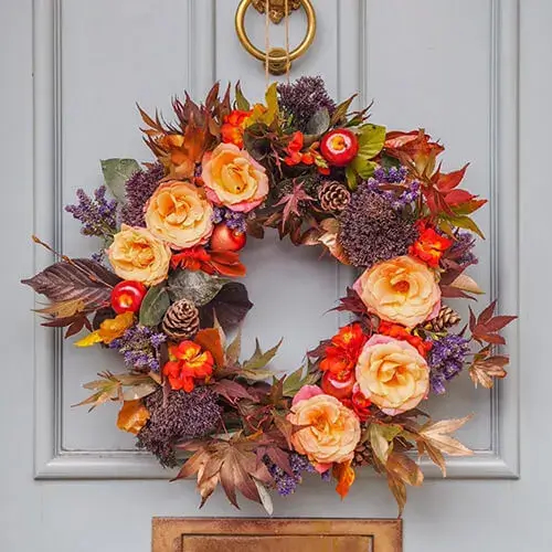 An autumnal floral wreath on a front door.