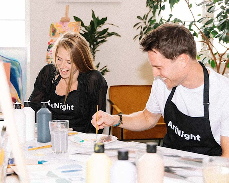 Two people happily painting together. 