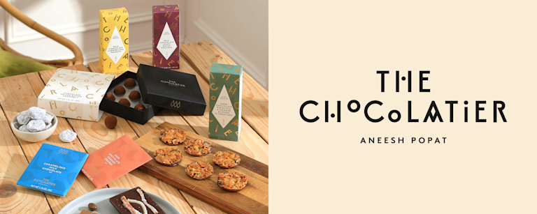 A selection of delicious-looking chocolate truffles and florentines, next to The Chocolatier's logo