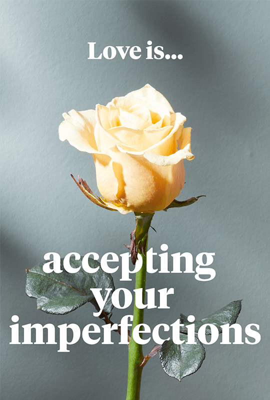 A pale yellow rose with the words 'Love is... accepting your imperfections'
