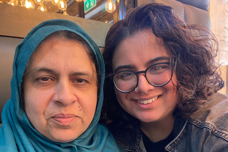Azmat and Rizwana smile at the camera. Azmat wears a turquoise headscarf.