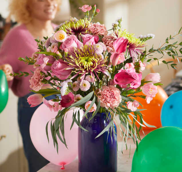 Pink bouquet of Bloom and Wild flowers in a dark blue vase