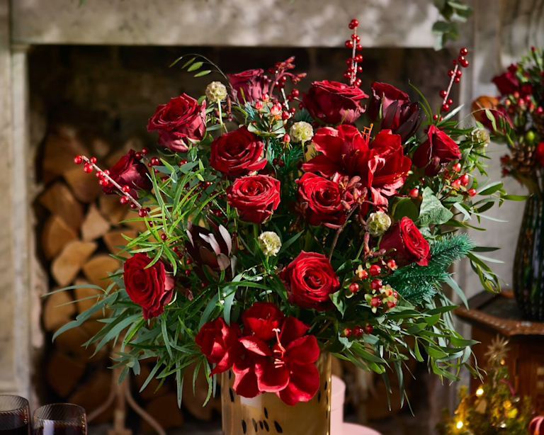 A big red bouquet, including roses, ilex berries, scabiosa, chasmanthium grass, eucalyptus, asparagus fern, pine, leucadendron, hypericum berries and kangaroo paw.