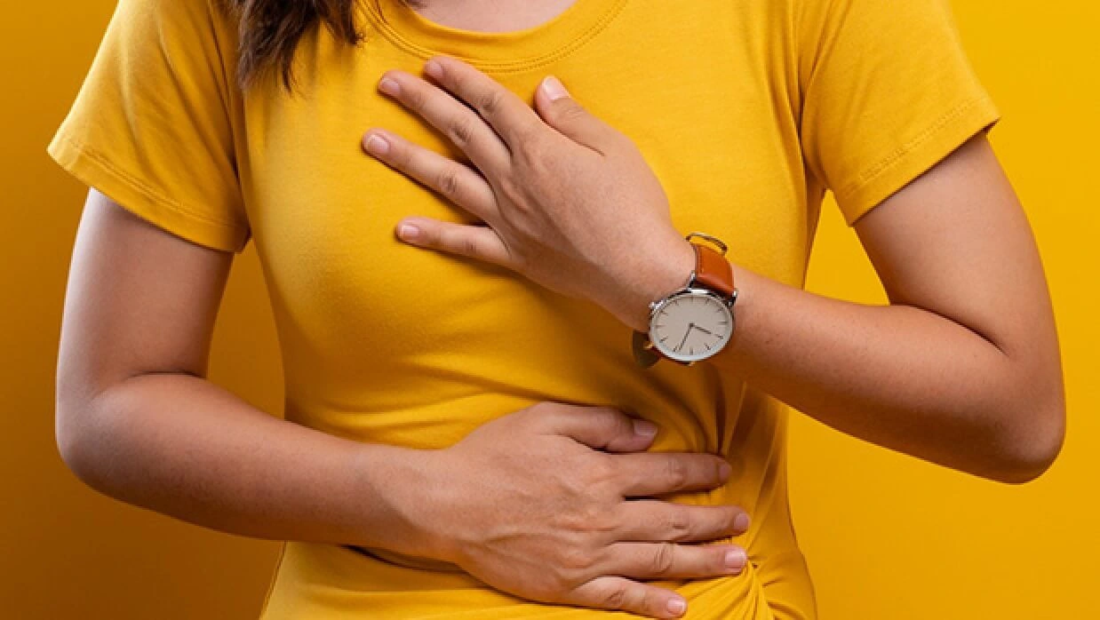 Woman with heartburn clutching chest