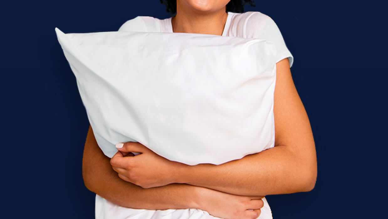 Person clutching pillow around their chest