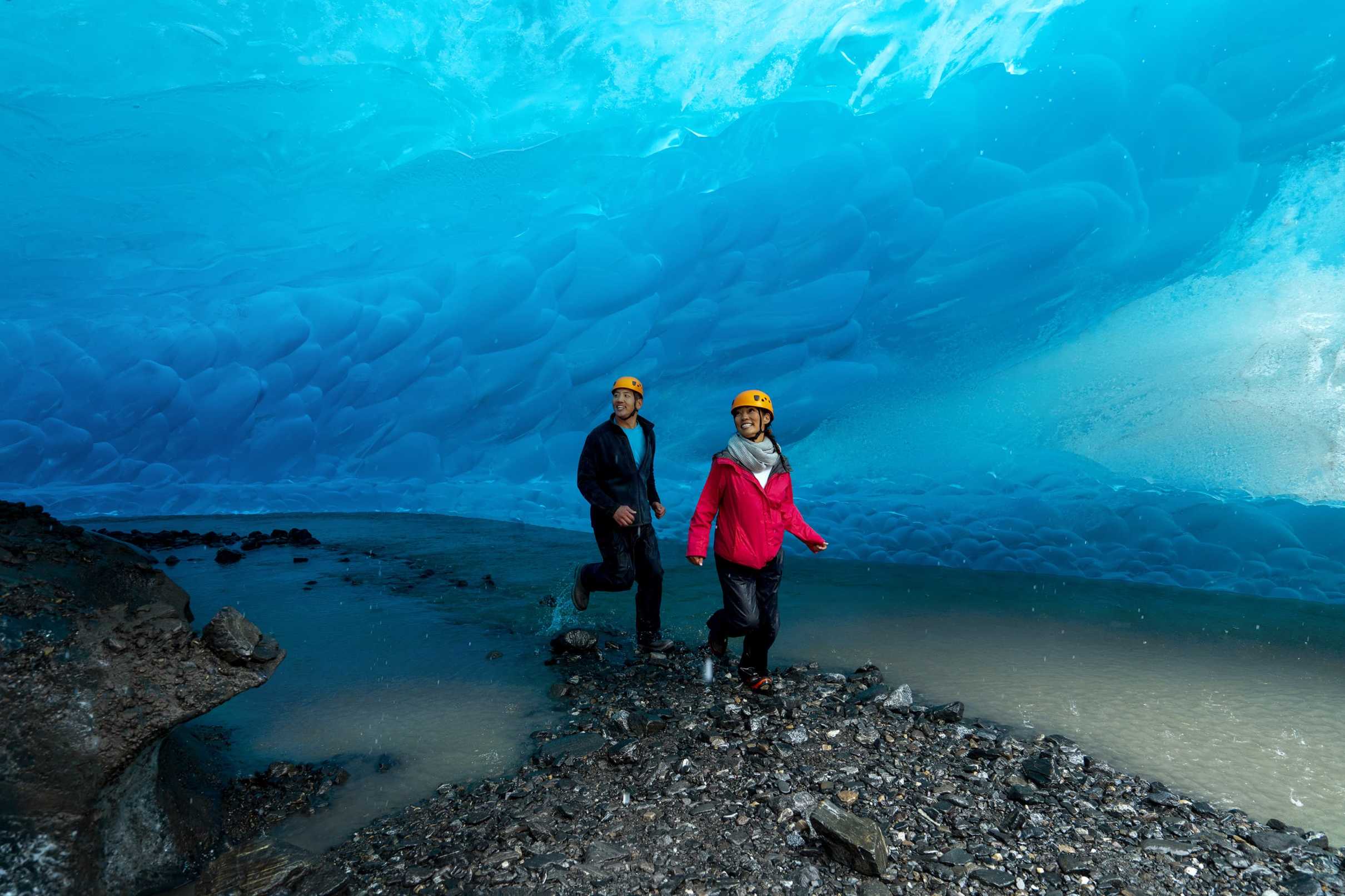 Two people next to a glacier
