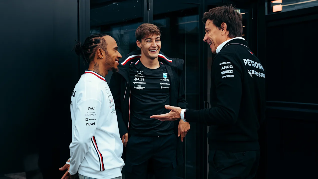 Toto Wolff, Lewis Hamilton, and George Russell chatting 16x9