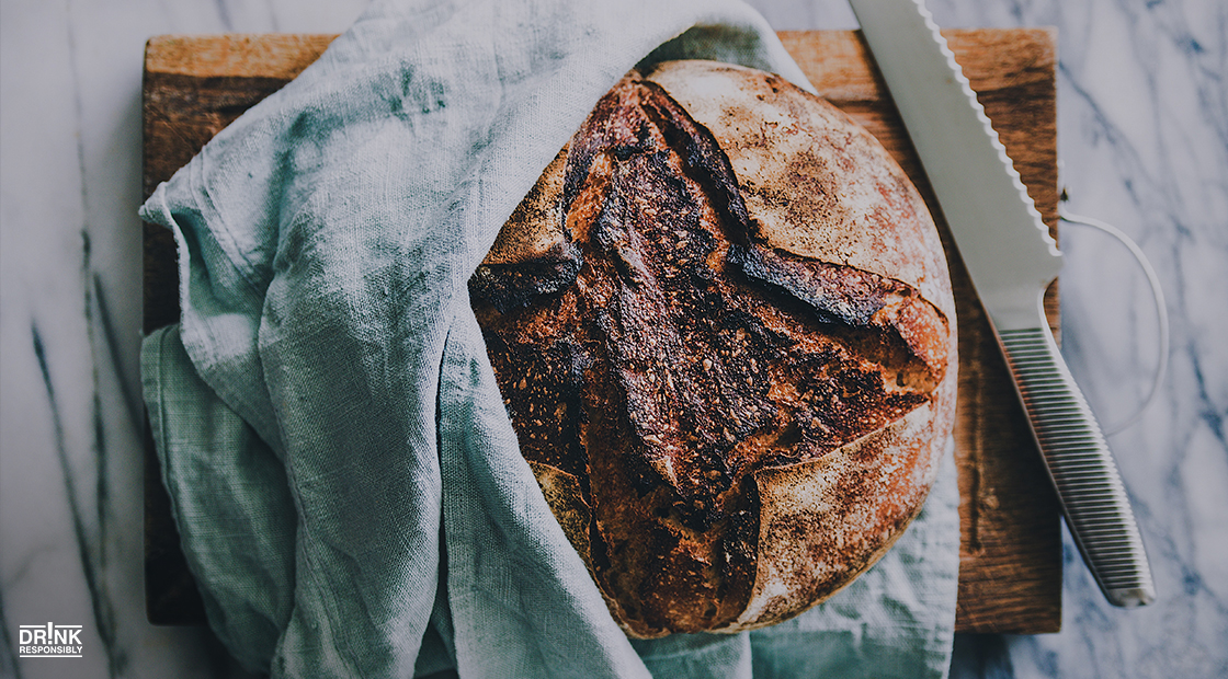 there is a loaf of bread on a cutting board with a knife