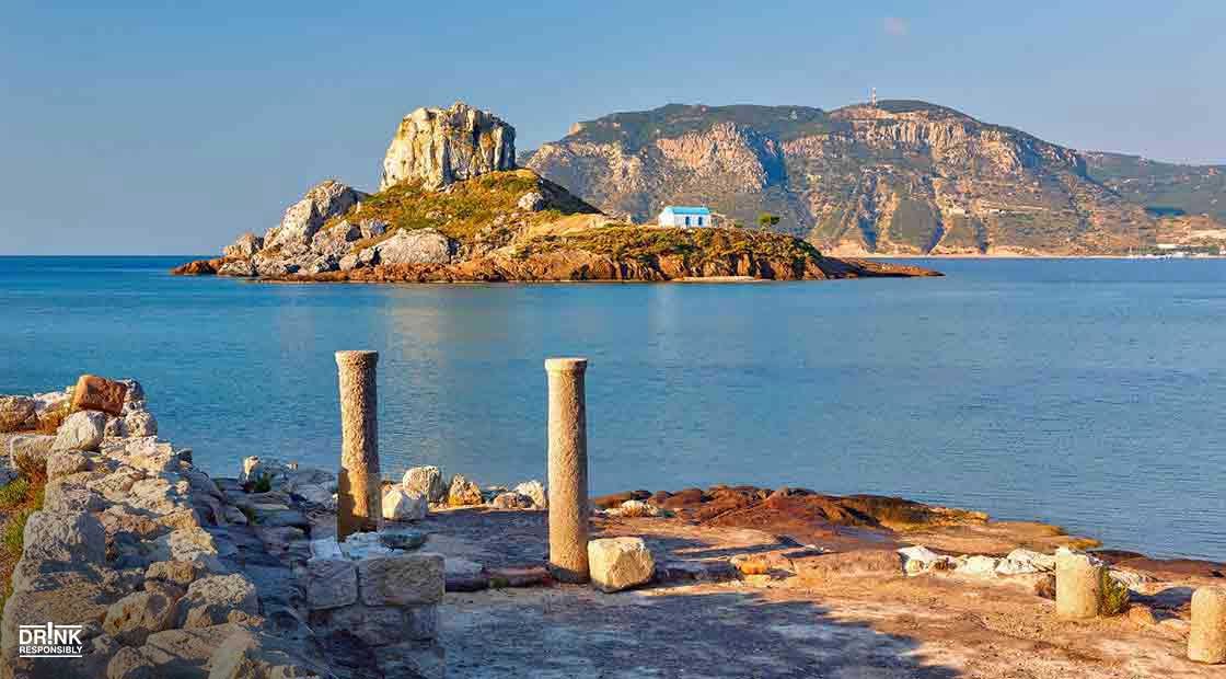 there are columns in the foreground of a body of water