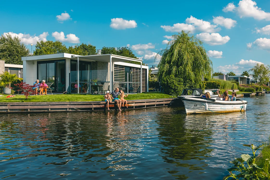 EuroParcs Veluwemeer family with grandparents in garden boat passes by