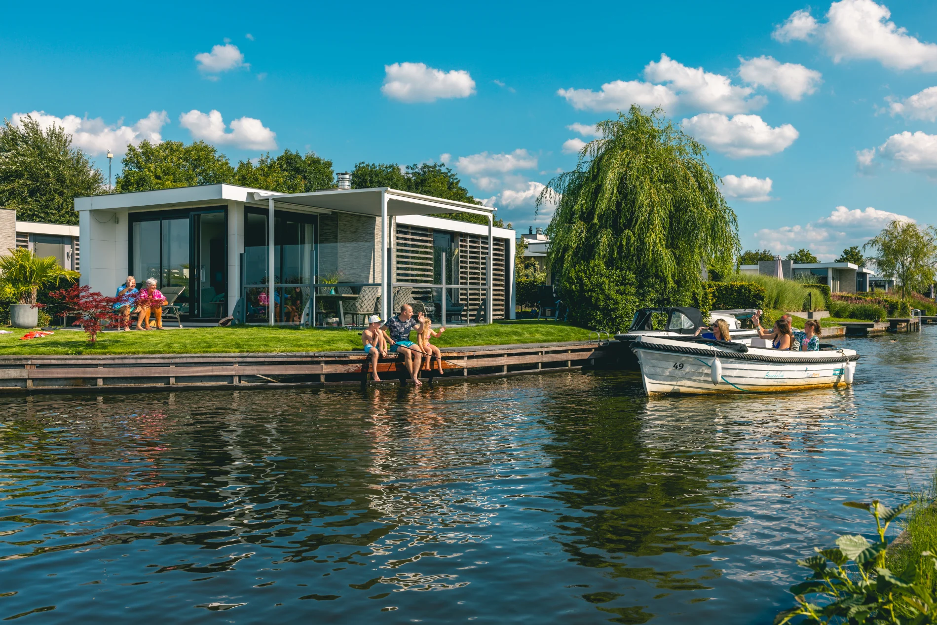 EuroParcs Veluwemeer family with grandparents in garden boat passes by