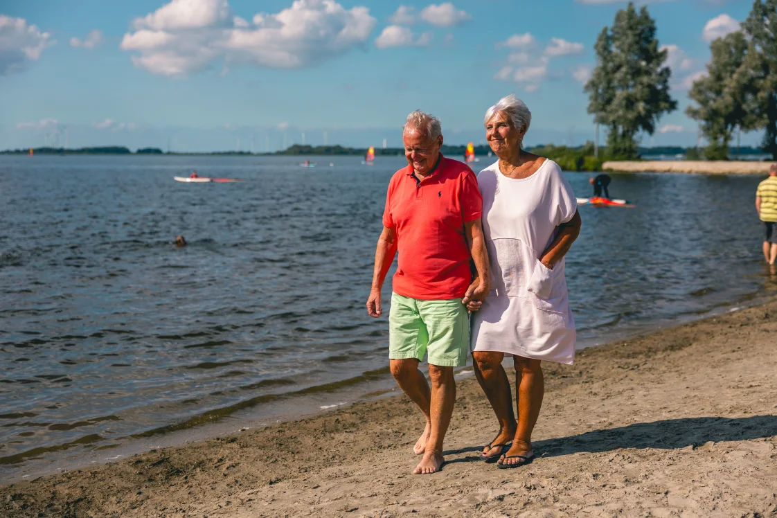 older couple walking at the beach at the water sun summer 