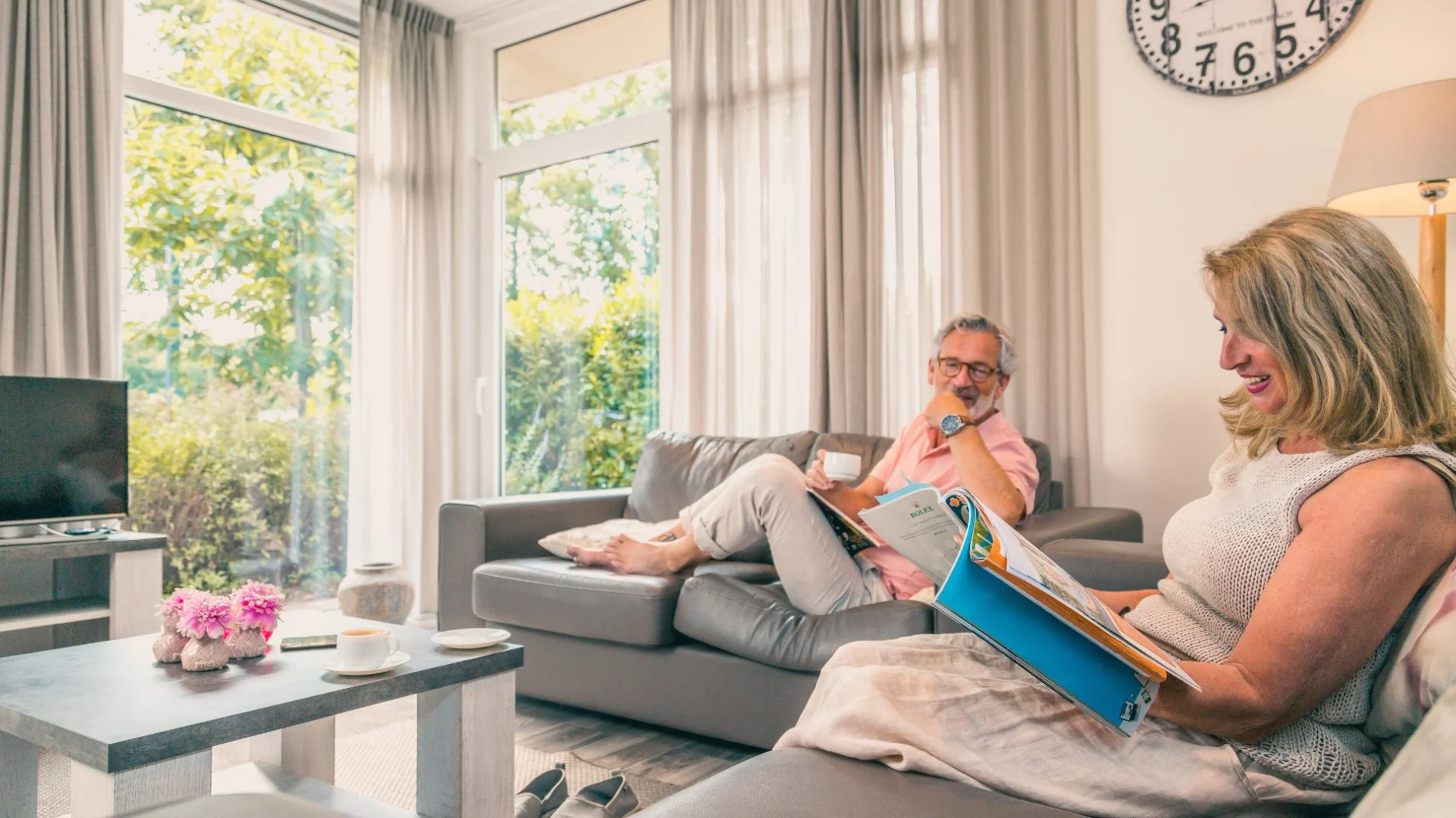 EuroParcs Restervallei couple on sofa reading brochures