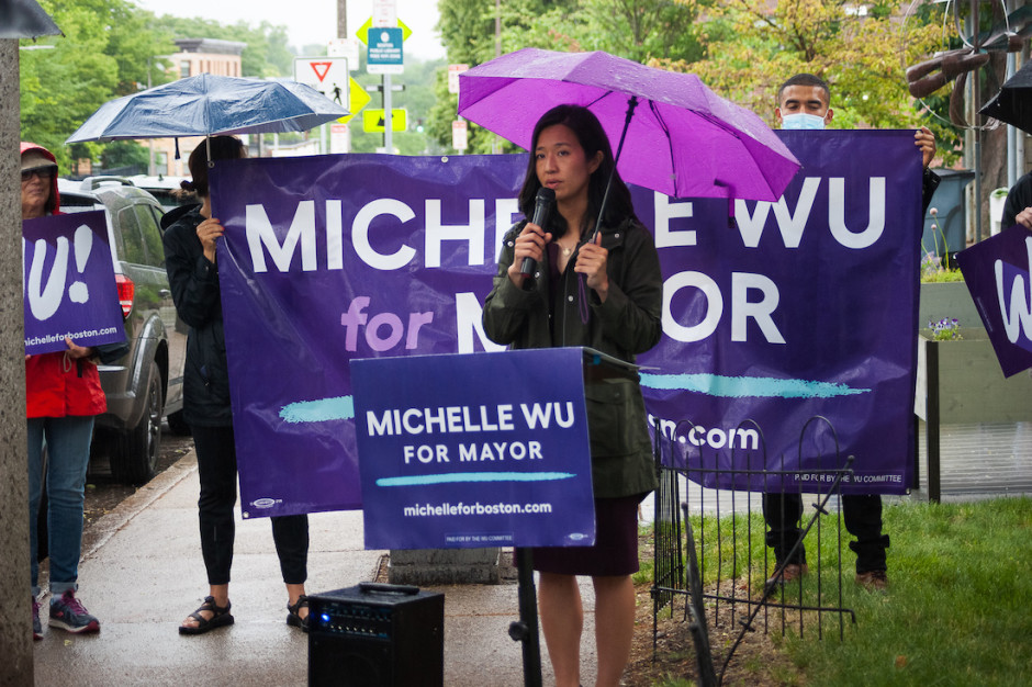 Michelle Wu holds an umbrella and speaks at a housing justice presser.
