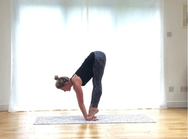 Image of woman doing standing forward bend pose