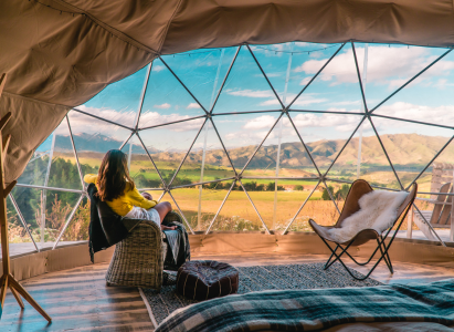 A woman sat in a dome glamping pod