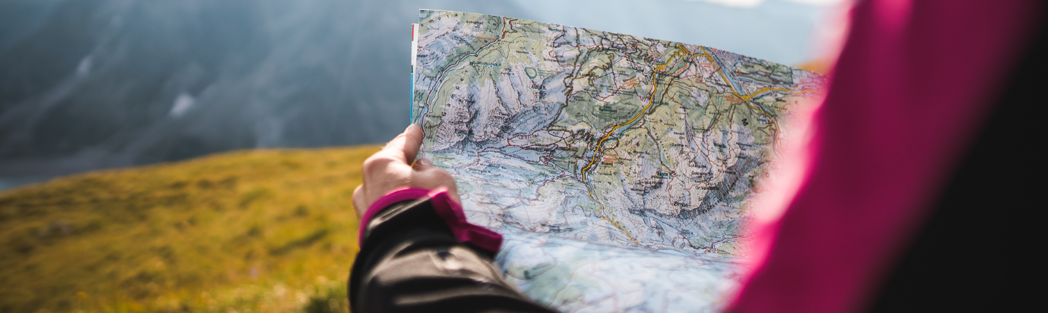 Adventurous Girl navigating in with a Topographic Map in the beautiful Mountains of the Austrian Alps