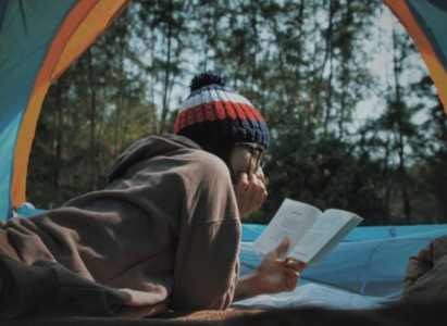 Camper reading in a tent 