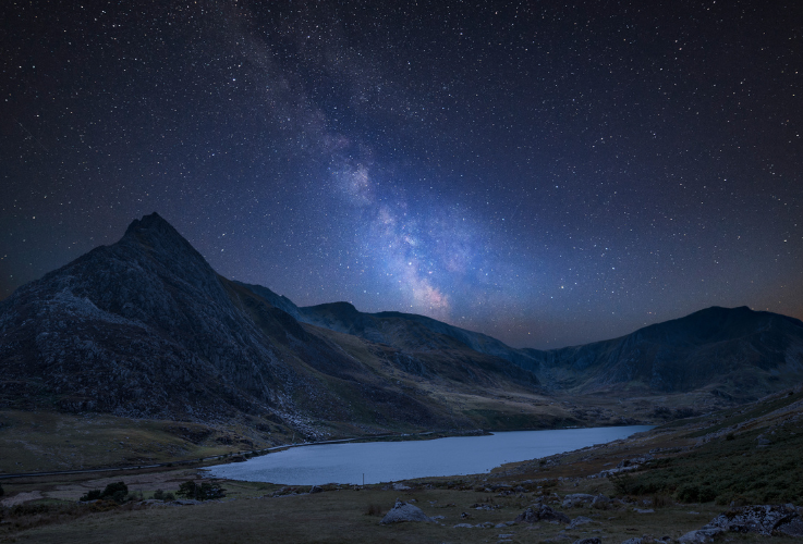 Stunning vibrant Milky Way composite image over Beautiful landscape image of countryside around Llyn Ogwen in Snowdonia