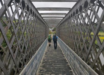 Footpath bridge crossing the River Spey with lattice covering