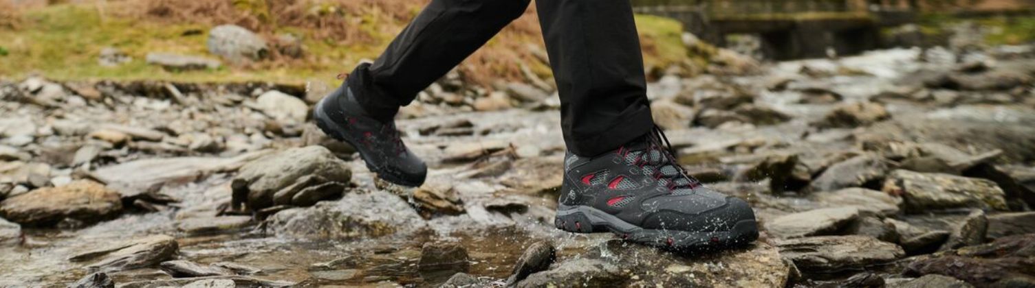 A man walking across a brook wearing Regatta holcombe walking boots