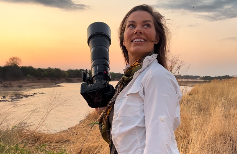 Hannah Stitfall wearing Craghoppers NosiLife Adventure Shirt and trousers, carrying a camera