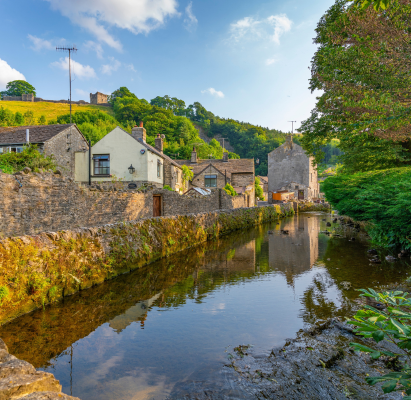 View of Castleton village and stream overlooked by Peveril Castle