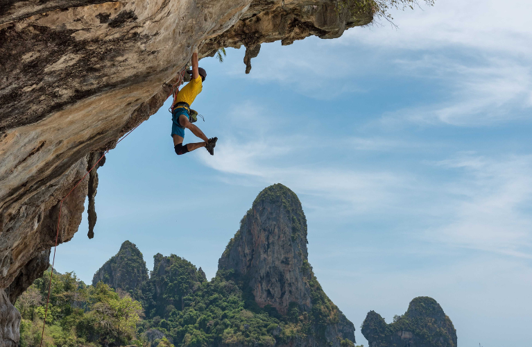 Rock climber hanging from under an inverted cliff