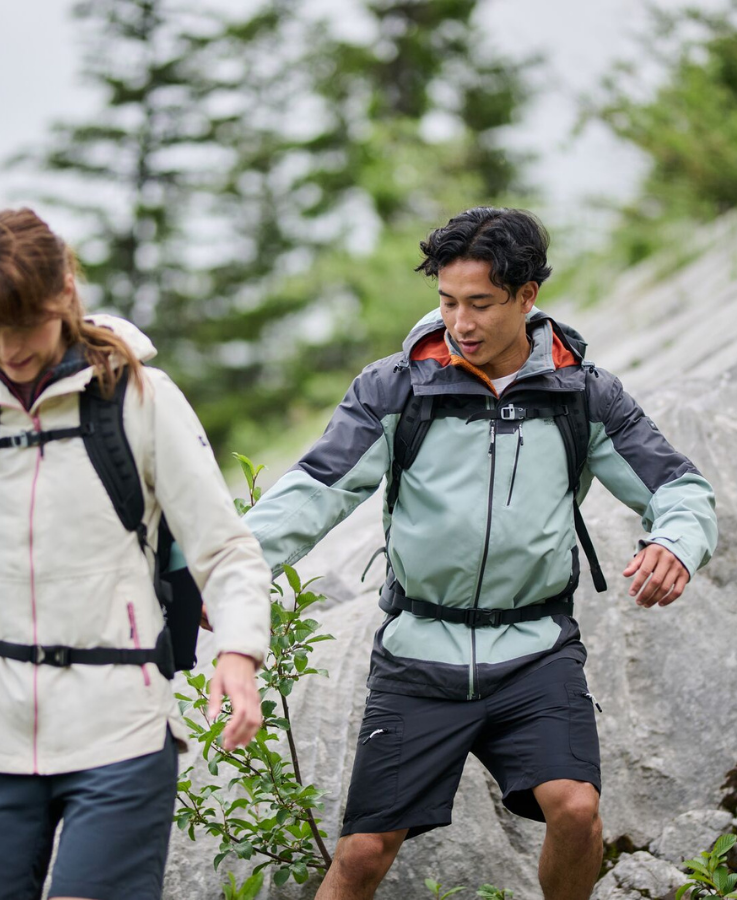 Two people hiking wearing Regatta outdoot clothing. A man wears a Regatta waterproof with a pair of Cargo Shorts