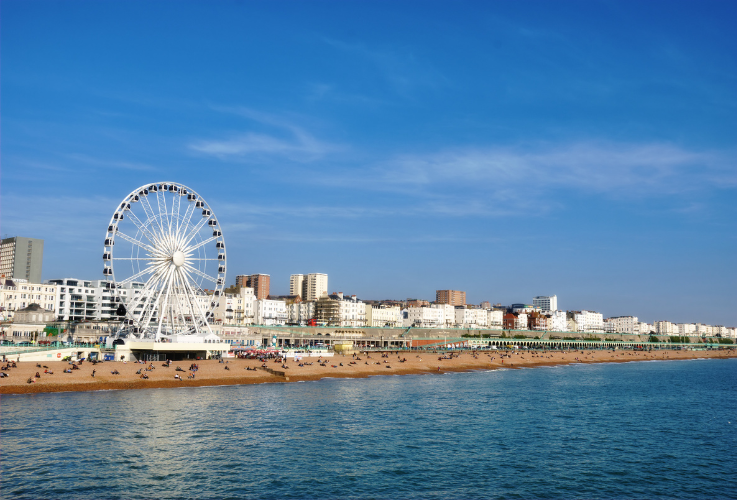 Panoramic view along Brighton Beachfront with the promenade and Ferris Wheel backed by highrise buildings