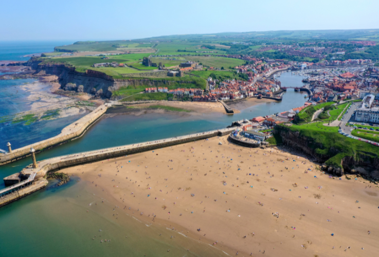 Aerial photo of the beautiful town of Whitby in the UK, North Yorkshire in the UK showing the beach front and the village centre and harbour