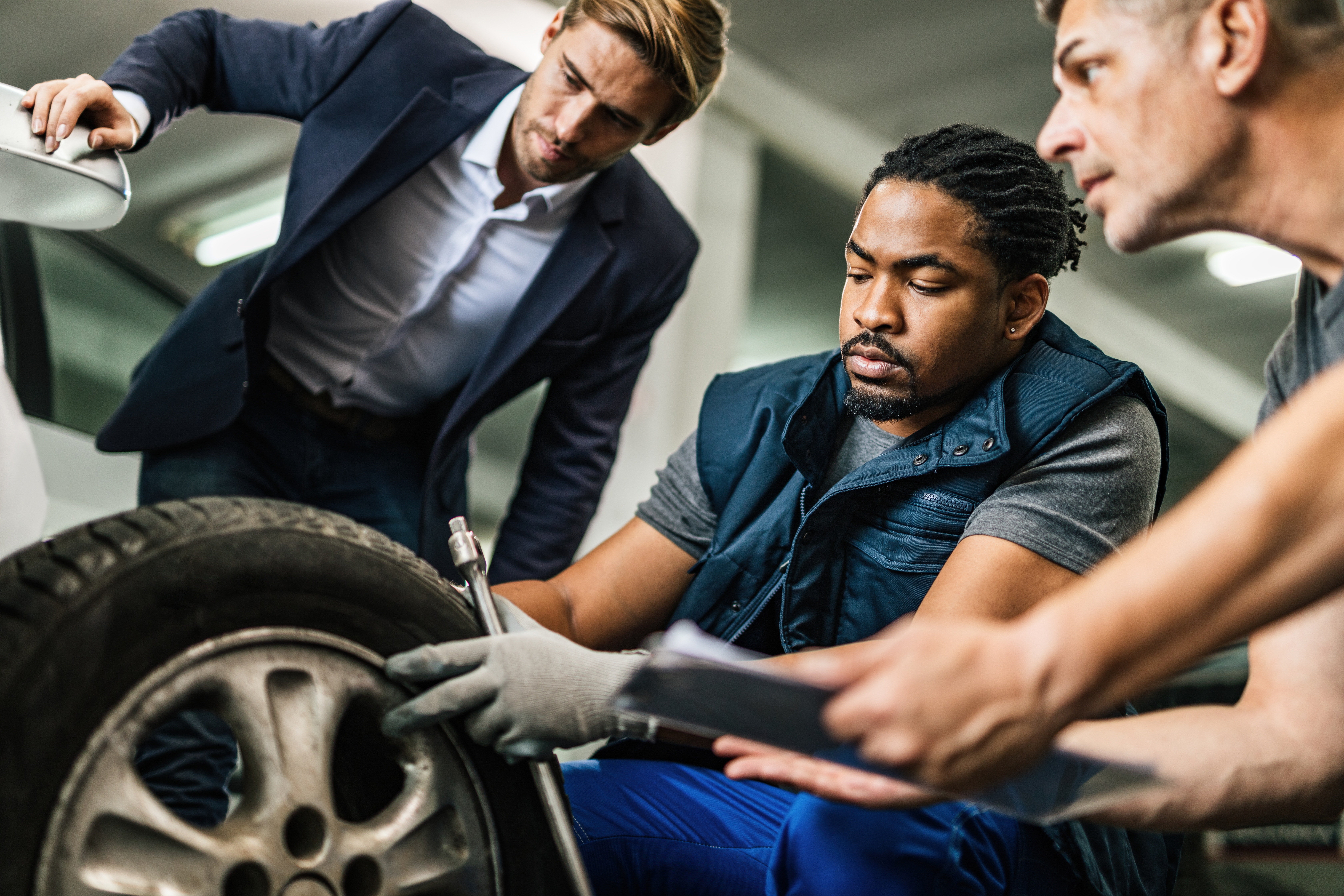 auto-mechanics-repairing-tire-of-customer-s-car