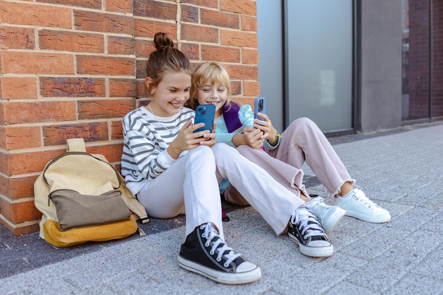 Deux enfants utilisent les médias sociaux sur leurs téléphones intelligents.