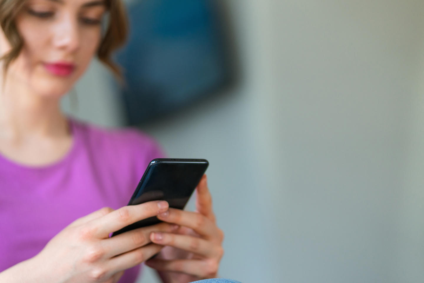 Une adolescente fait défiler des médias sociaux sur un téléphone mobile.