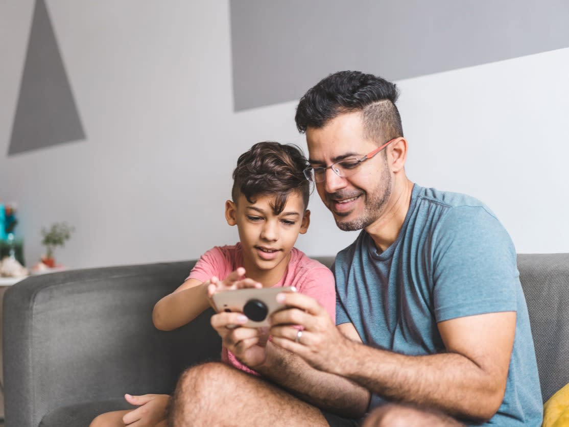 Father and child looking at a smartphone. 