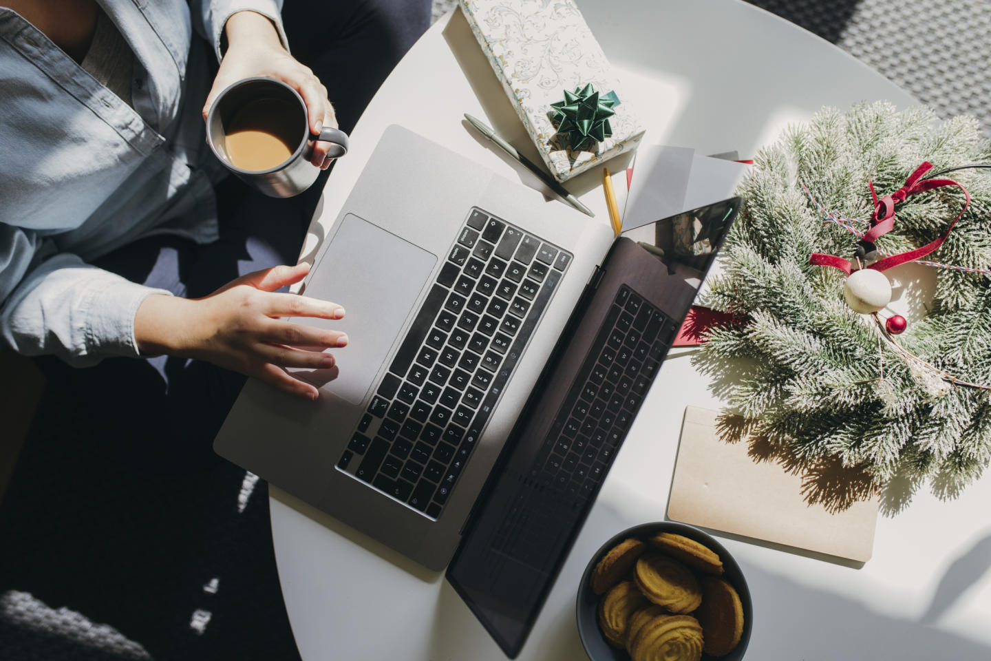 aerial view of a person working on their laptop with Christmas presents and decorations on their desk