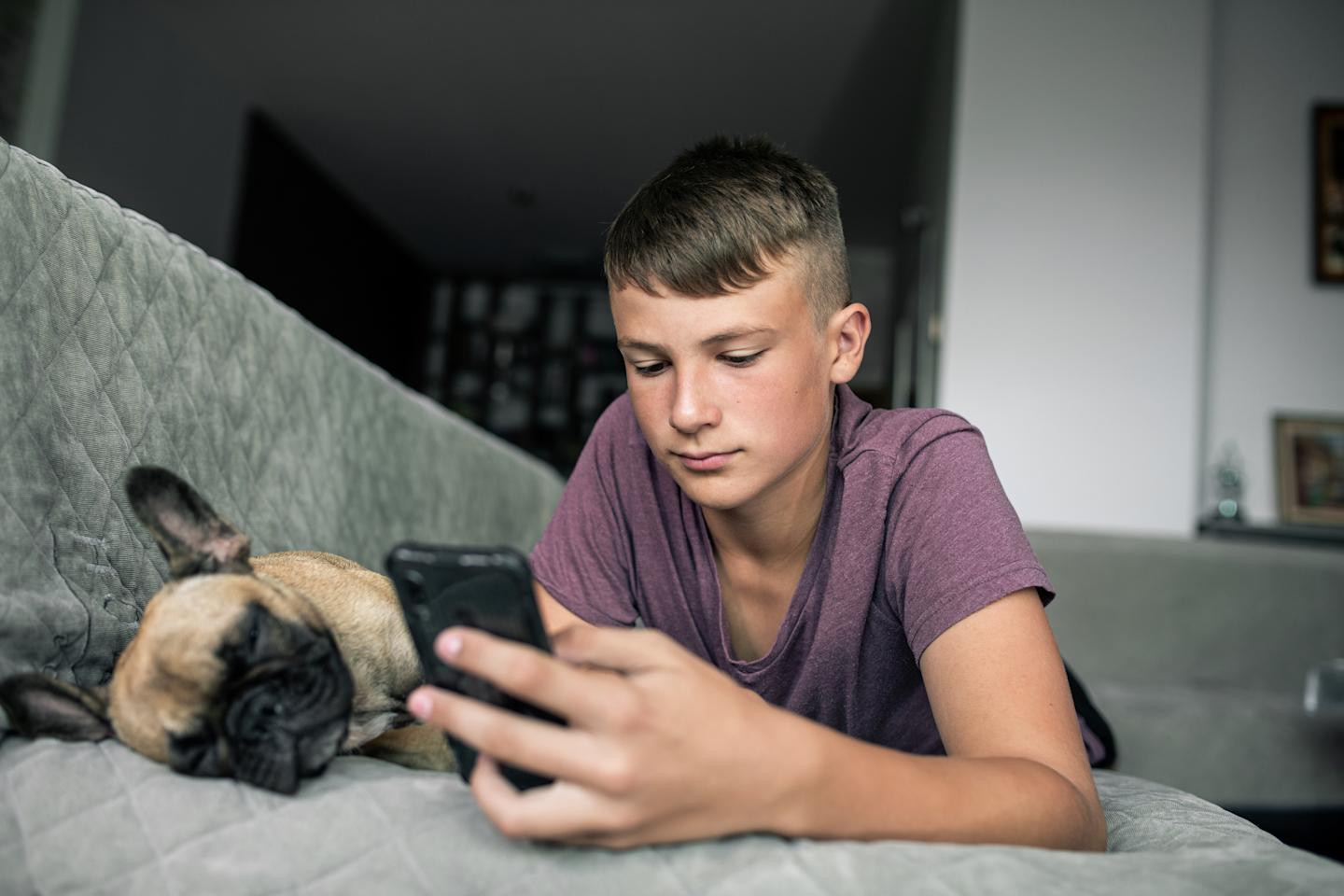 A teen chatting with an AI chatbot on a smartphone. 