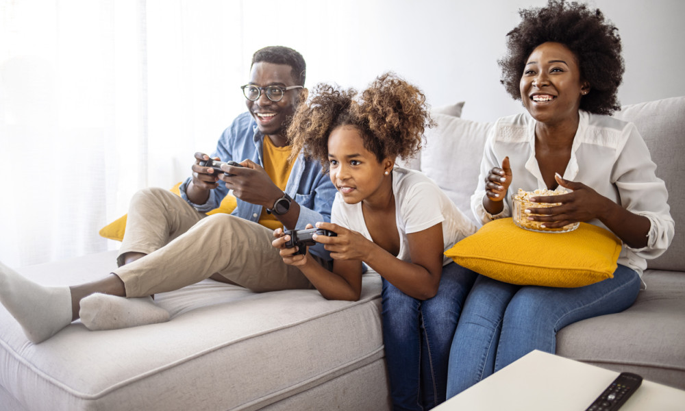 A family plays video games together on the couch