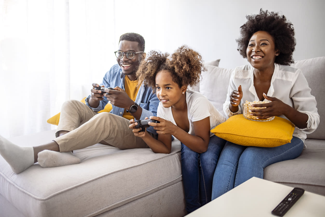 A family plays video games together on the couch