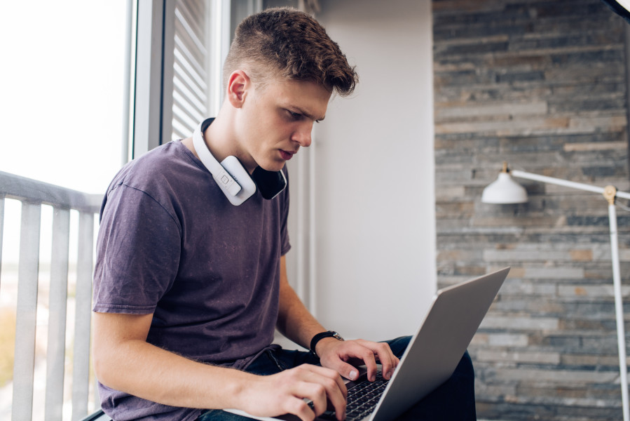 Un adolescent utilisant un ordinateur portable.

