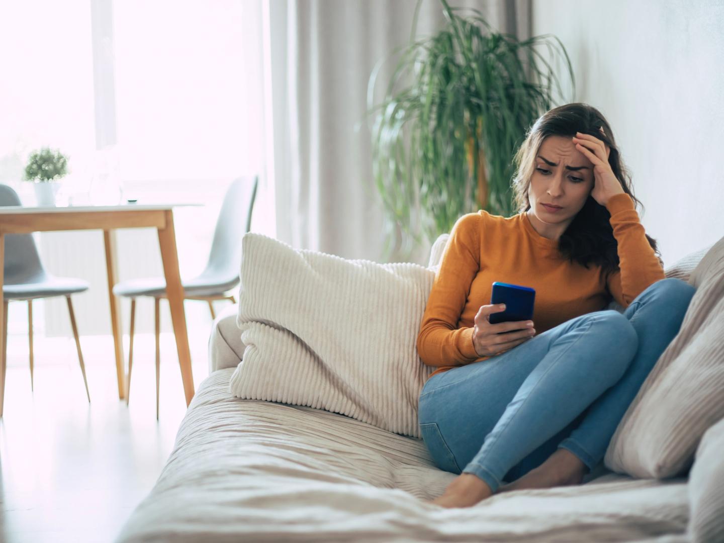 A frustrated adult looking at smartphone.